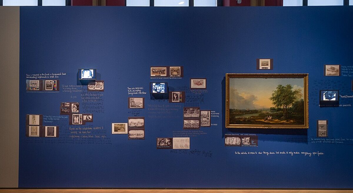 An exhibition wall with paintings and archival material