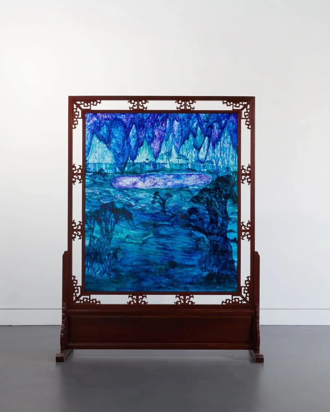 A painting by Christopher Ge, set in a carved wooden screen